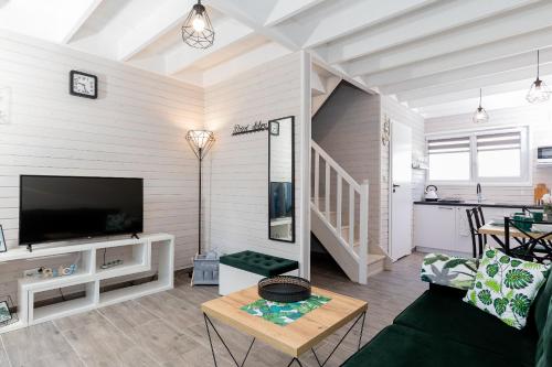 a living room with a couch and a tv and a table at Villa6 I Domki Pobierowo in Pobierowo