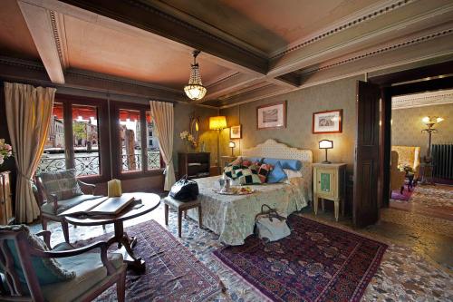 - une chambre avec un lit, une table et des chaises dans l'établissement Palazzetto Pisani Grand Canal, à Venise