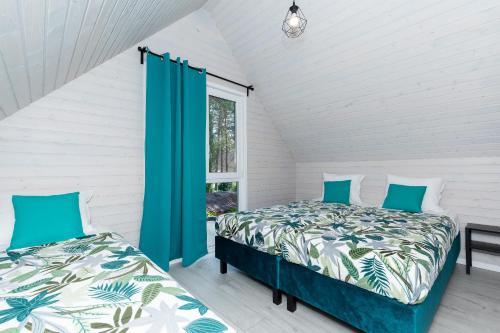 a bedroom with two beds and a window at Villa6 I Domki Pobierowo in Pobierowo