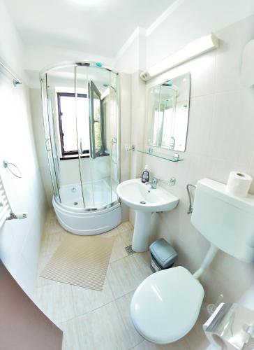 a white bathroom with a shower and a sink at Vila Sabarel in Eforie Sud