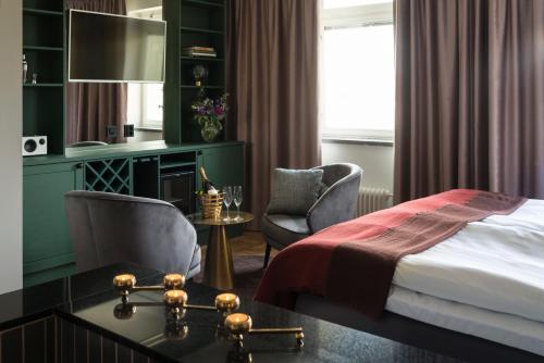 a hotel room with a bed and a desk and chairs at Näsby Slott in Täby