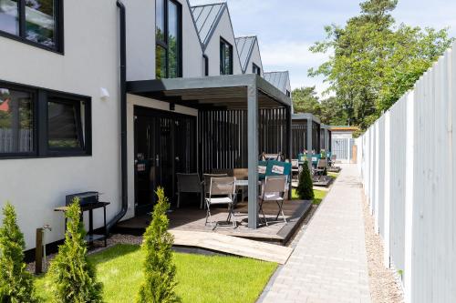 a patio with a table and chairs next to a white building at Villa6 I Domki Pobierowo in Pobierowo