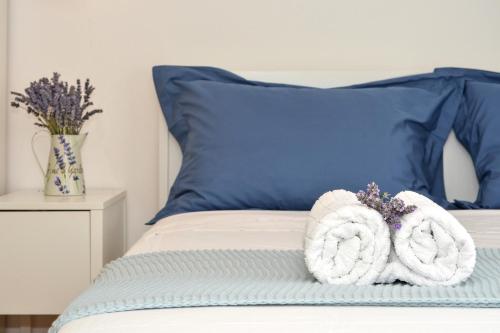 a bed with blue pillows and towels on it at Bora bora Apartment in Kaštela