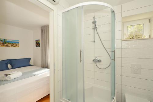 uma casa de banho com um chuveiro e uma porta de vidro em Bora bora Apartment em Kaštela
