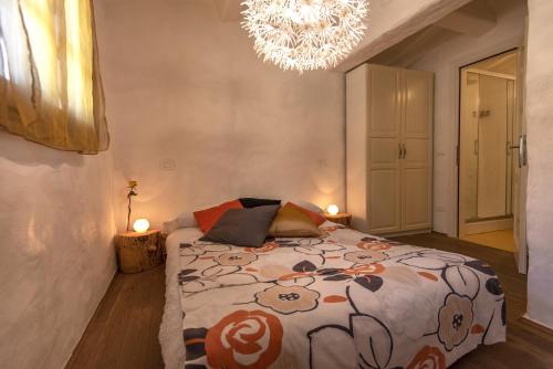 a bedroom with a bed and a chandelier at B&B Country House Poggio Del Drago in Ponticino