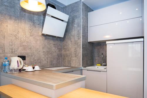 a kitchen with white cabinets and a white refrigerator at Hotel Vlaho in Skopje