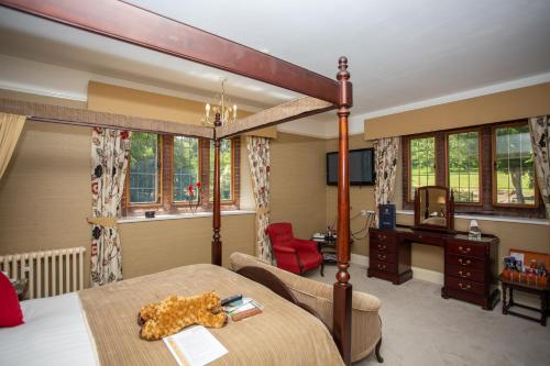 a bedroom with a bed and a desk in a room at Dales Country House Hotel in Sheringham