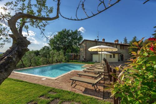 a pool with chairs and an umbrella next to a house at B&B Country House Poggio Del Drago in Ponticino