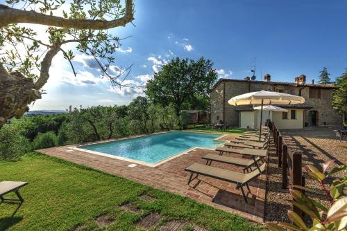 a swimming pool with chairs and an umbrella at B&B Country House Poggio Del Drago in Ponticino