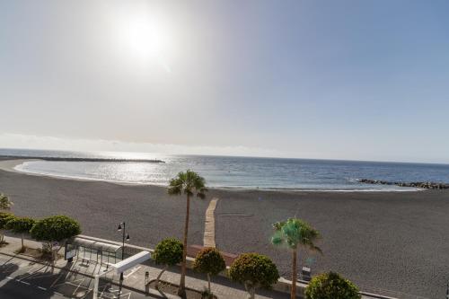 a view of a beach with palm trees and the ocean at Hotel Emblemático Holiday Time in Santa Cruz de la Palma