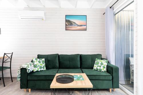 a green couch in a living room with a table at Villa6 I Domki Pobierowo in Pobierowo