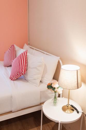a white couch with pillows and a table with a lamp at House Of Papa Bangkok Siam in Bangkok