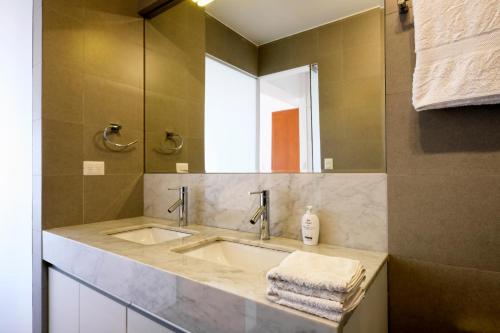 La salle de bains est pourvue d'un lavabo et d'un miroir. dans l'établissement InkaHuset Miraflores Oceanfront, à Lima