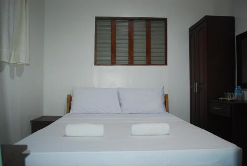 una camera da letto con un letto bianco e una finestra di 13 ways Room Rentals a Panglao