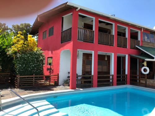 a red building with a swimming pool in front of a house at Da Fabio in Negril