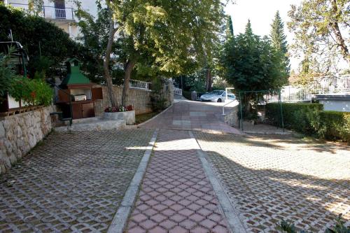a cobblestone street with a tree and a building at Apartments Matic in Njivice