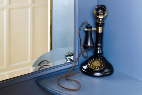 an old fashioned telephone sitting on a blue counter at Commodore Hotel in Cobh