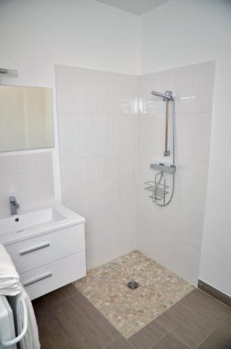 a white bathroom with a sink and a mirror at Le Clos des Salins in Toulouse