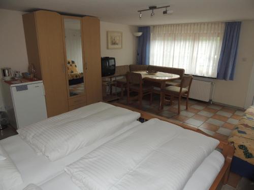 a living room with two beds and a table at Gästehaus und Ferienwohnung Bächle in Bad Peterstal