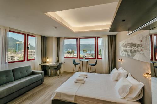 een hotelkamer met een groot bed en een bank bij Centar Novi in Herceg-Novi