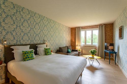 1 dormitorio con 1 cama blanca grande en una habitación en Hôtel Restaurant Gastronomique La Huchette, en Mâcon