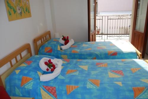 two twin beds with towels on them at Baia Unci in Canneto