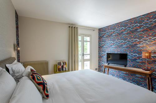 a bedroom with a white bed and a blue wall at Hôtel Restaurant Gastronomique La Huchette in Mâcon