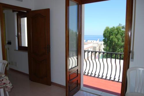 a room with a balcony with a view of the ocean at Baia Unci in Canneto