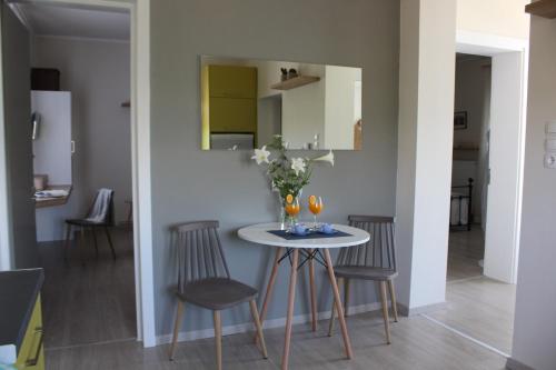 a small table with chairs and a vase of flowers at ORANGE GARDEN in Aigio