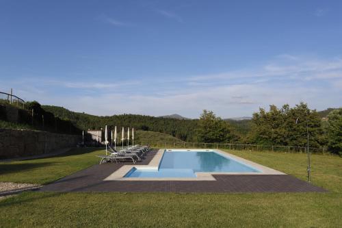 a swimming pool in the middle of a grass field at Ternaldo Agroturismo & Relax in Arco de Baúlhe