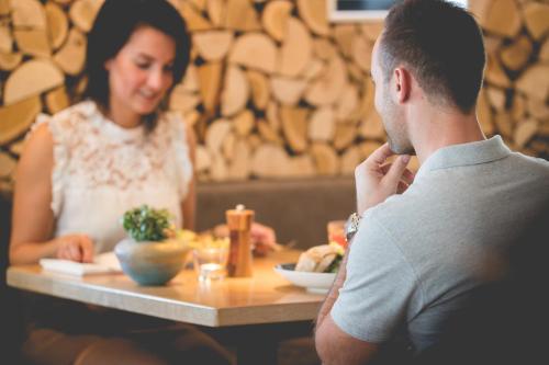 a man and a woman sitting at a table in a restaurant at Hotel de Sterrenberg - Adults Only in Otterlo