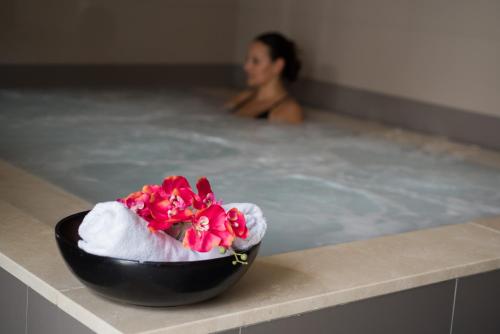 a woman in a bath tub with a bowl of flowers at Vila Gale Collection Elvas in Elvas