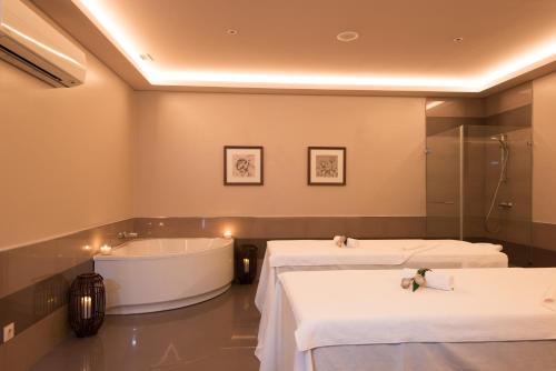 a bathroom with two beds and a bath tub at Vila Gale Collection Elvas in Elvas