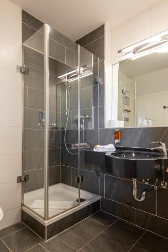 a bathroom with a shower and a sink at Avenon Privathotel Schwaiger Hof in Schwaig bei Nürnberg