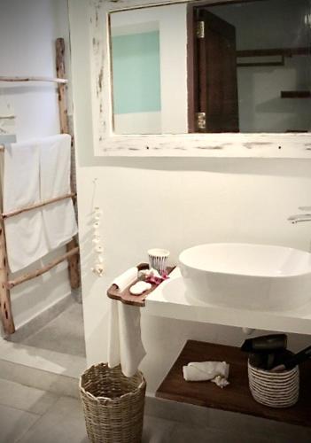a white bathroom with a sink and a mirror at Kiwengwa Bungalow Boutique Resort in Kiwengwa