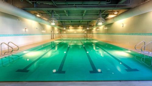 a large indoor swimming pool with green water at Ballard Inn in Seattle