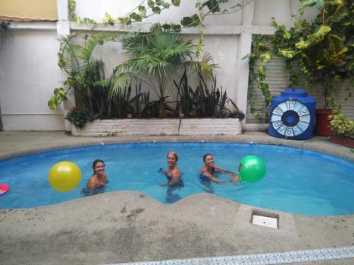 three children playing in a swimming pool with balloons at My Best Stay Piedra del Mar in Puerto López