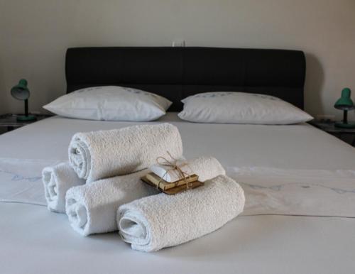uma pilha de toalhas numa cama com almofadas em Studio apartment Laura || em Murter