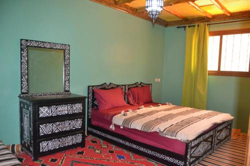 a bedroom with a bed with red pillows and a mirror at Auberge Matat in Imlil