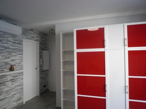 Habitación con puertas rojas y blancas y pared de ladrillo. en IPANEMA Residence Le Minerve Studio, en Cannes