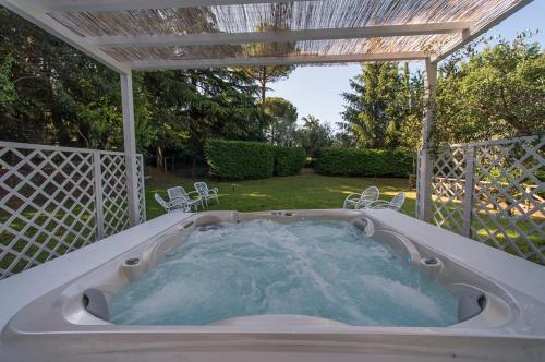 a hot tub in a backyard with a pergola at Country Lodge B&B in Siena