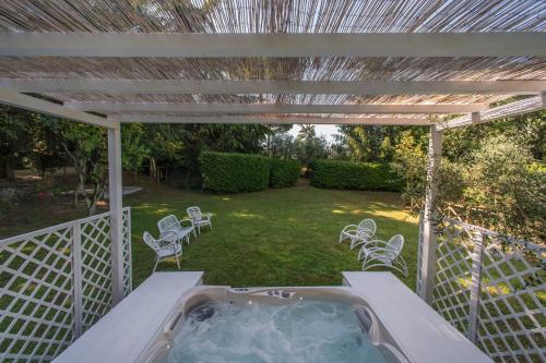 a hot tub on a patio under a pergola at Country Lodge B&B in Siena