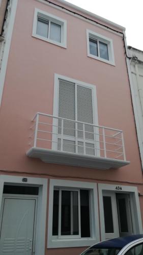 a pink building with a balcony on top of it at City Center House in Ponta Delgada