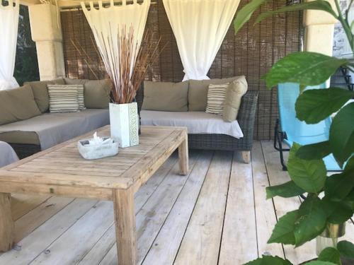 a patio with a wooden table and a couch at Stone house Chiara Seaview in Funtana