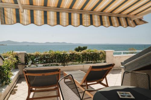 a patio with chairs and a table and the ocean at Apartments Lucija in Zadar