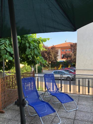 two blue chairs sitting under an umbrella at La Casa di Olivo in Tassullo