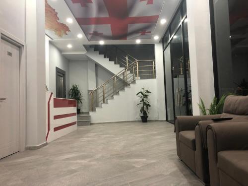 a lobby with a staircase and a stair case at Hotel Royal Georgia in Batumi