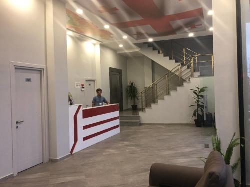 a man standing at a counter in an office lobby at Hotel Royal Georgia in Batumi