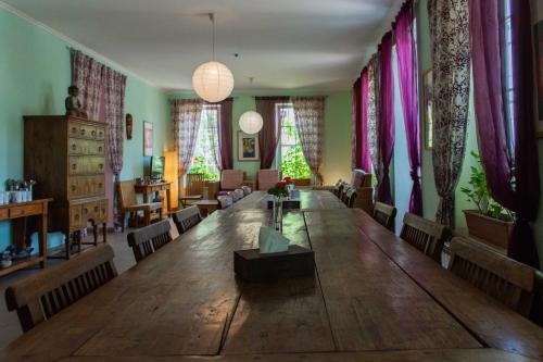 a large wooden table in a room with curtains at JR's House in Yerevan