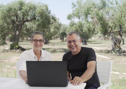 a man and woman sitting at a table with a laptop at giardino del tempo in Merine